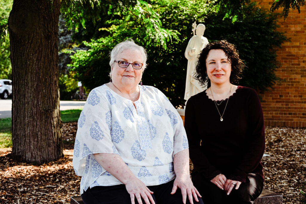 Pam and Christel de Jesus, a financial health counselor at Catholic Charities for the Diocese of Green Bay, Inc., sitting outside.